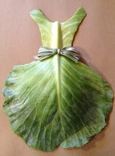 a large green leaf with a bow on it's back hanging from a wall