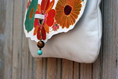 "► Our FREE delivery is TRACKED, secure and super FAST! Please provide a PHONE number for DHL express delivery. This bridal white leather crossbody purse with a flowery design is entirely hand-made with the best quality Spanish cowhide leather. The bag is handpainted with a floral design and colorful ornaments in vibrant colors like orange, turquoise, and gold. It has a pending that closes the flap and is decorated with natural stones such as tiger eye stone, amethyst, and coral. It is very ligh Spring Leather Shoulder Bag Gift, Spring Gift Leather Shoulder Bag, Spring Leather Shoulder Bag For Gift, White Bohemian Leather Bags, Bohemian White Leather Bags, Bag With Flowers, Colorful Ornaments, Handpainted Bags, Flowers Colorful