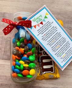 a jar filled with lots of candy next to a card