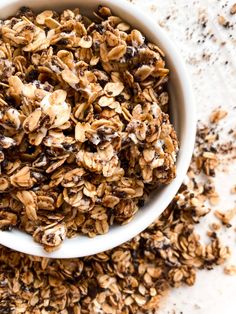 a white bowl filled with granola on top of a table