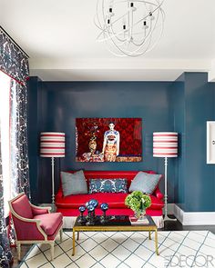 a living room with blue walls and red furniture