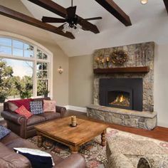 a living room filled with furniture and a fire place in front of a large window