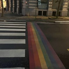 a rainbow painted on the street in front of a building