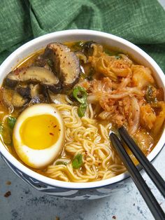 an overhead view of a bowl of ramen with noodles, egg and mushrooms