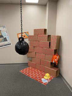 an office cubicle with boxes and a black bag hanging from the ceiling