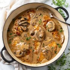 a pot filled with meat and mushrooms covered in gravy on top of a table