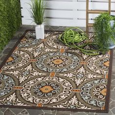 an outdoor area rug with potted plants on it