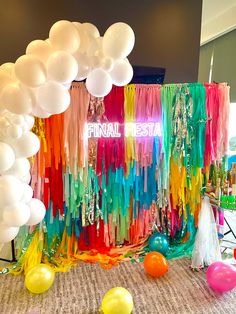 balloons, streamers and streamers are on the floor in front of a backdrop