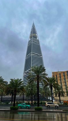 a very tall building sitting next to palm trees in front of a large body of water