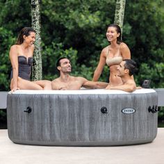 three women and two men are sitting in an outdoor hot tub