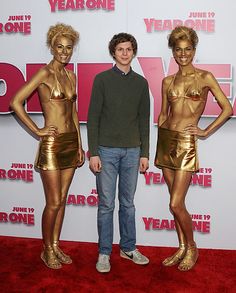 three people standing on a red carpet in front of a poster for the movie's year one