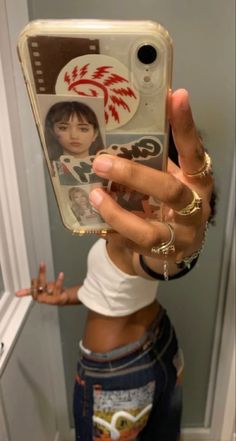 a woman taking a selfie in front of a mirror with her cell phone up to her face