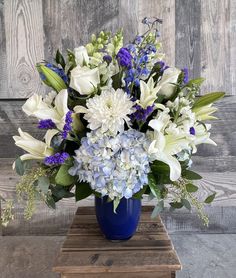 a blue vase filled with white and purple flowers