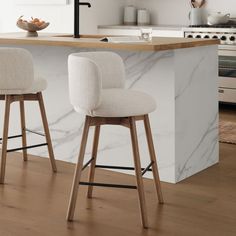 two white stools sitting in front of a counter