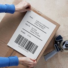 a person holding a piece of paper with a barcode on it next to a pair of scissors