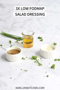 three small bowls filled with salad dressing on top of a white counter next to green herbs