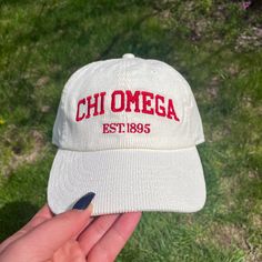 someone is holding up a white hat with the word'chiomega estr'on it