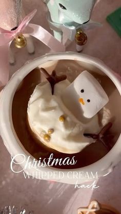 a cup filled with hot chocolate and marshmallows in the shape of a snowman