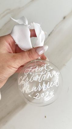 a hand holding a glass ornament with the words together