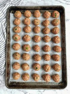 raw meatballs on a baking sheet ready to go into the oven