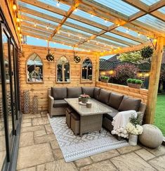 an outdoor living area with couches, tables and lights on the outside patio roof