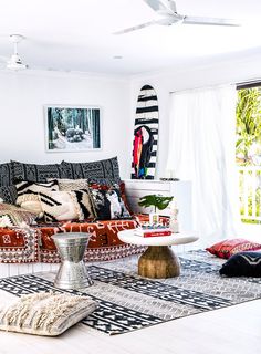 a living room with white walls and black and white decor on the couches, rugs and tables