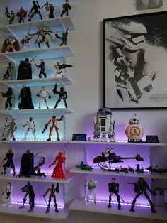 star wars action figures are displayed on shelves in a room with purple lighting and artwork