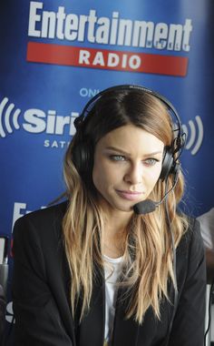 a woman with headphones sitting in front of a microphone