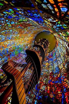 the inside of a building that has stained glass windows and colorful lights on it's ceiling