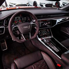 the interior of an audi car with leather seats and steering wheel, including dashboard controls