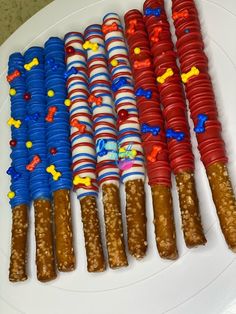 a white plate topped with lots of different types of candy canes on top of each other