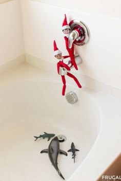 two elfs are in the bathtub and one is on the sink with his head down