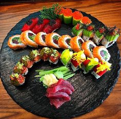 an assortment of sushi on a black plate