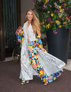 a woman in a colorful dress is posing for the camera