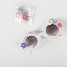 The cutest little sunglasses for a little human in your life!These sunglasses come with fun floral embellishments and your flower girls' name for a one-of-a-kind look -- perfect for your flower girl proposals, wedding party photoshoots, and even as a wedding DIY! Choose from two colors - white or peach - and whether you want them assembled or to DIY them yourself (you'll just need glue).Glasses are UV400 and fit most girls and children aged 3-12. If they become detached, individual pieces can ca White Plastic Sunglasses For Gift, White Plastic Sunglasses As Gift, Cute White Sunglasses For Gift, Cute White Sunglasses As Gift, Cute White Sunglasses As A Gift, White Cute Sunglasses For Birthday, White Sunglasses For Spring Gift, Little Sunglasses, Flower Sunglasses