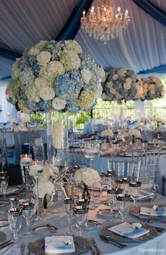 the centerpieces are arranged in clear vases with white roses and hydrangeas