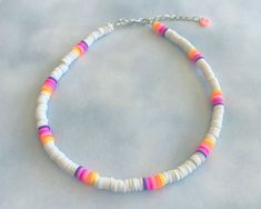 a multicolored beaded necklace on a silver chain with an orange, yellow, pink, and white stripe