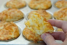 a hand holding a piece of food in a muffin tin