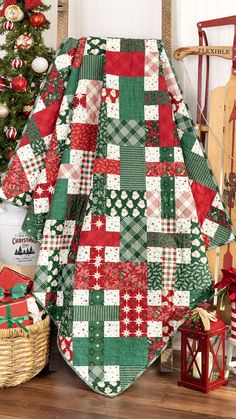 a quilted christmas tree skirt sitting on top of a wooden floor next to a christmas tree