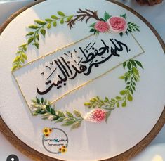 the embroidery is decorated with flowers, leaves and arabic calligraphy on a white surface