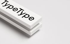 two white business cards with the word type printed on them, sitting side by side