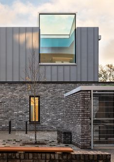 a brick building with a tree in front of it and a window on the side