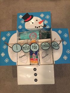 a snowman made out of candy in a box with the words i miss you on it