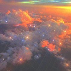 an aerial view of the sky and clouds with lights on them at sunset or sunrise