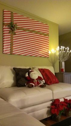 a living room decorated for christmas with white couches and red poinsettis