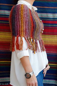 a woman standing in front of a multi colored striped wall with her hand on her hip