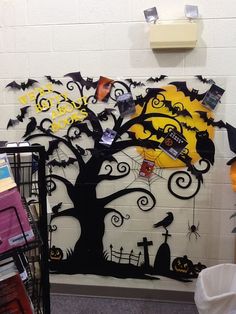 a wall with halloween decorations on it and a tree in the middle, surrounded by other items