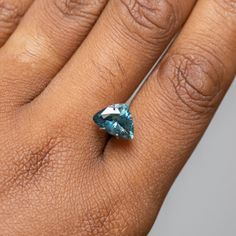 a woman's hand with a ring on it and a blue diamond in the middle