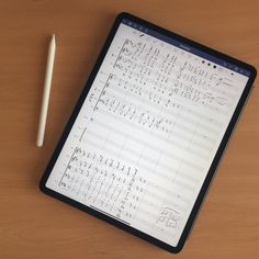 a tablet with music notes on it next to a pencil