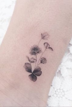 a black and white flower tattoo on the ankle